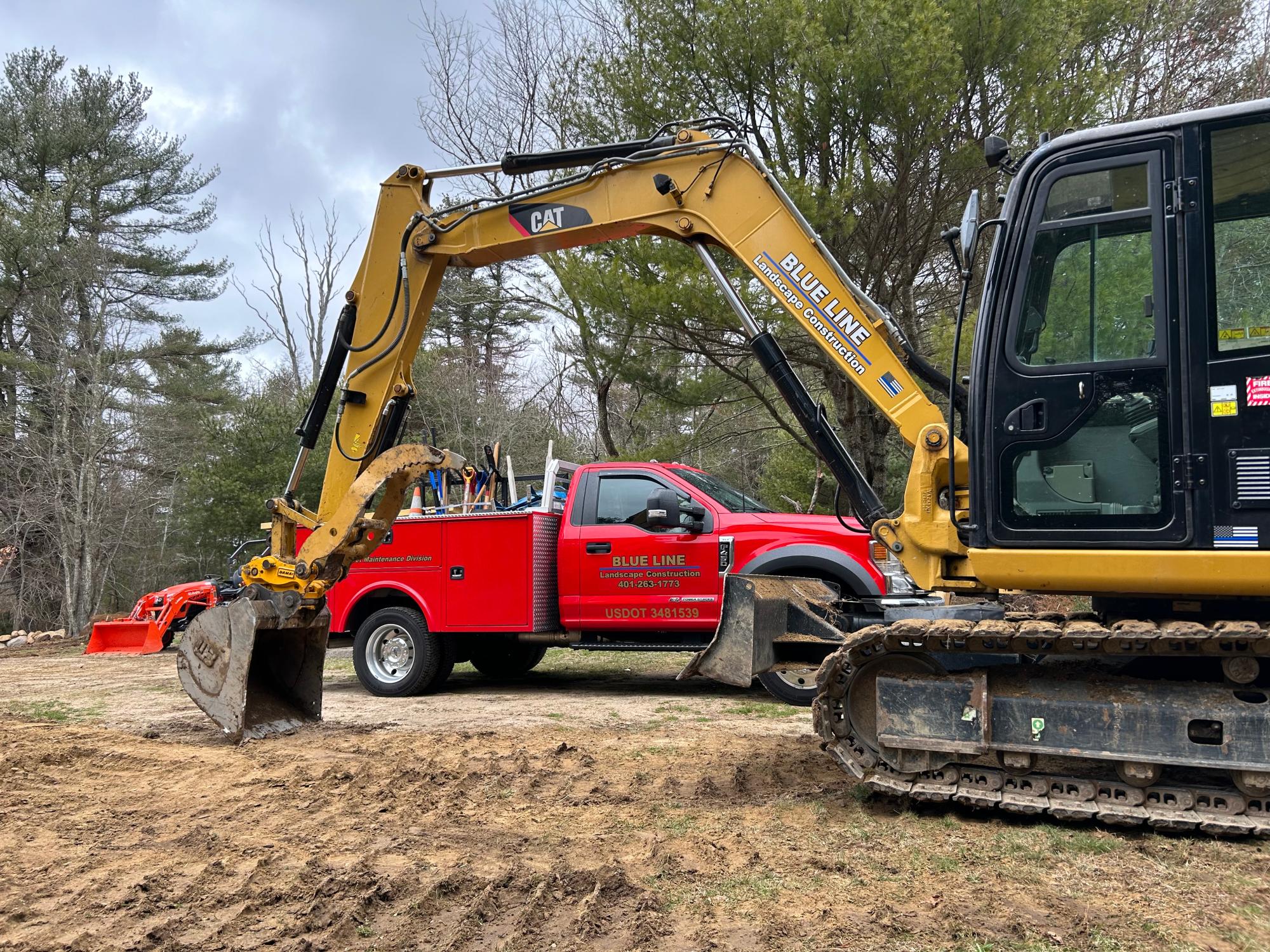 Blue Line branded excavator and service truck on a Rhode Island job site